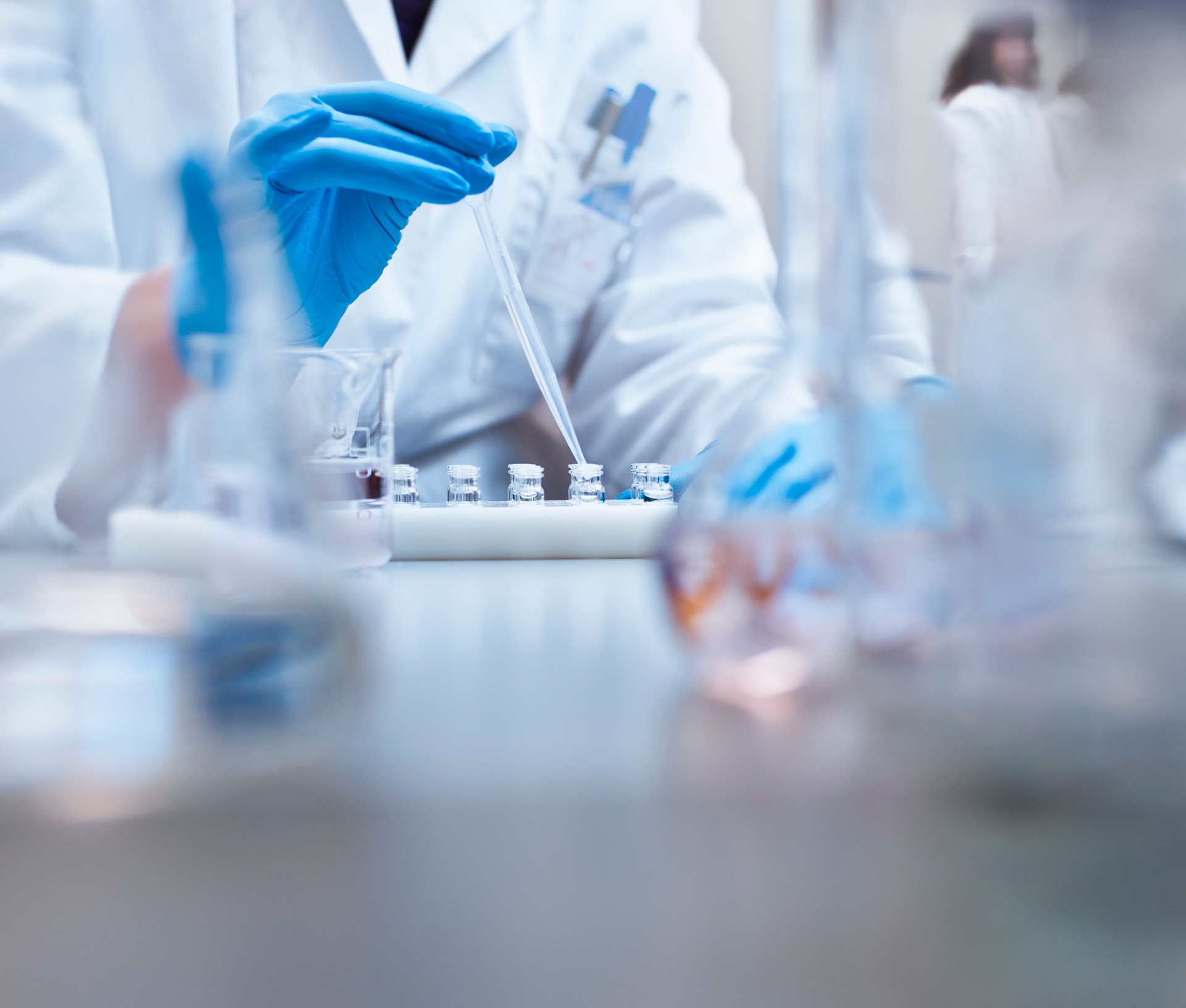 Chemist filling vials in experiment at laboratory